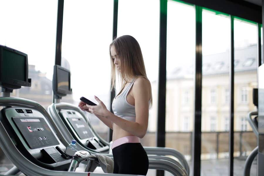 atleta femenina smartphone gimnasio 1 Atleta femenina con smartphone en gimnasio
