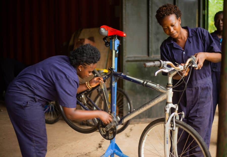 Mecánicas ajustando frenos y transmisión bicicleta